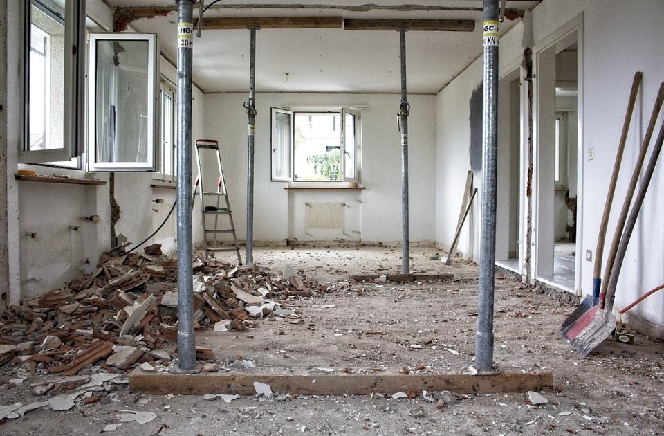 Interior demolition with support posts, rubble, and tools